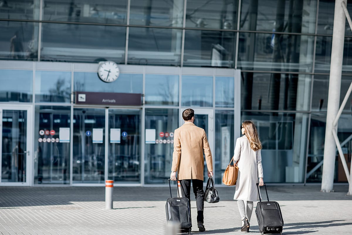 Couple arriving at airport terminal for private transfer service on the French Riviera