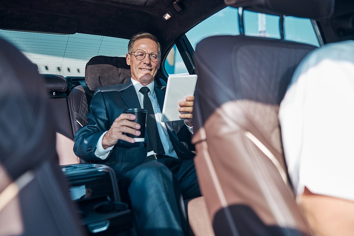 VIP client enjoying a comfortable airport transfer with coffee in luxury car on the French Riviera