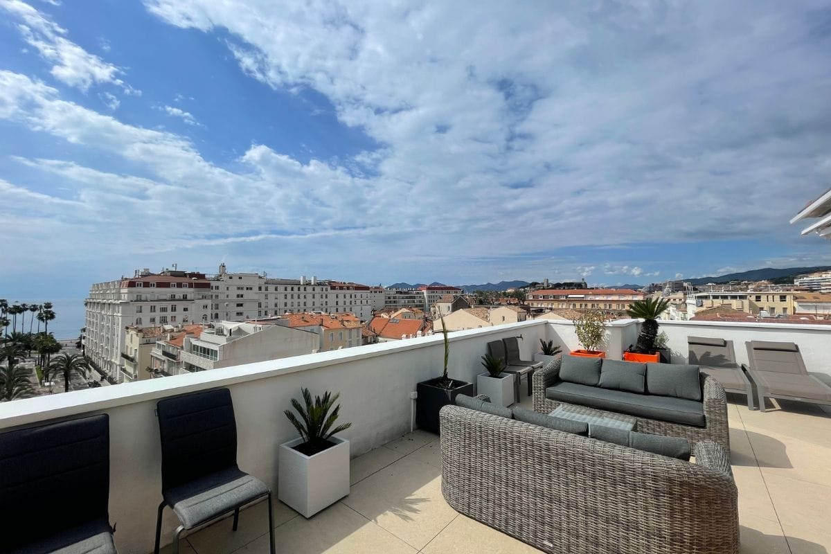 apartment-grand-palais-cannes-exterior-terrace-city-view Apartment Grand Palais in Cannes with a private rooftop terrace, lounge seating, and panoramic sea and city views.