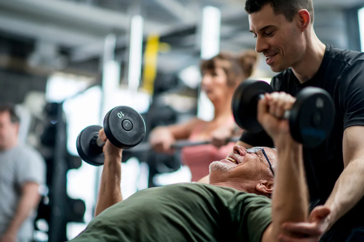 Private fitness trainer coaching a client with personalized dumbbell routine.