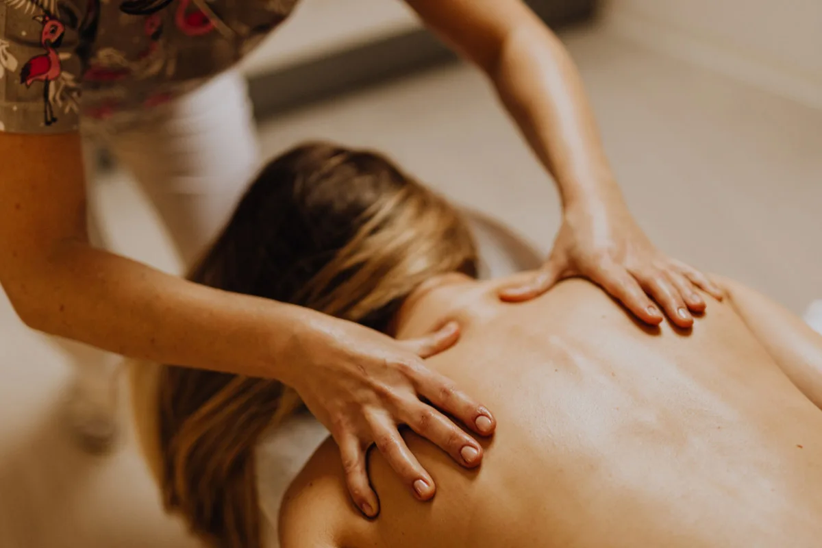 private-massage-service-french-riviera-relaxing-client-experience Private massage therapist giving a back massage to a client during in-villa wellness session.