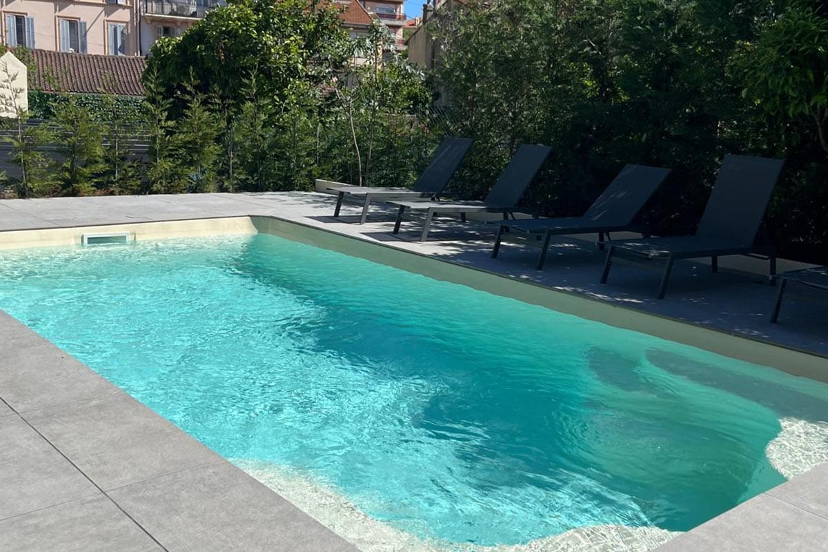 villa-betty-cannes-for-rent-exterior-modern-pool-terrace Villa Betty in Cannes – modern French Riviera villa with sleek sun loungers, private pool, and serene garden-lined terrace.