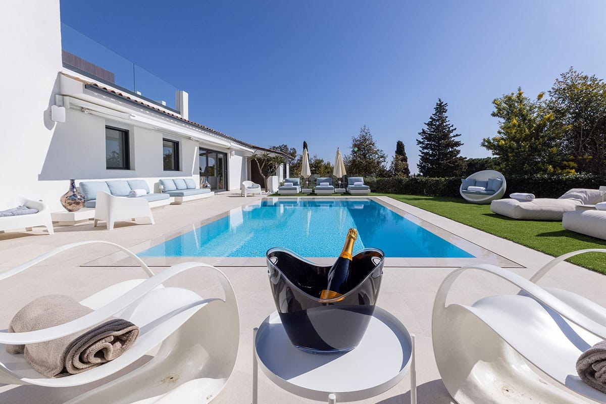 villa-erianne-cannes-modern-retreat-exterior-poolside Villa Erianne in Cannes with a private pool, modern lounge area and champagne setup for stylish outdoor relaxation.