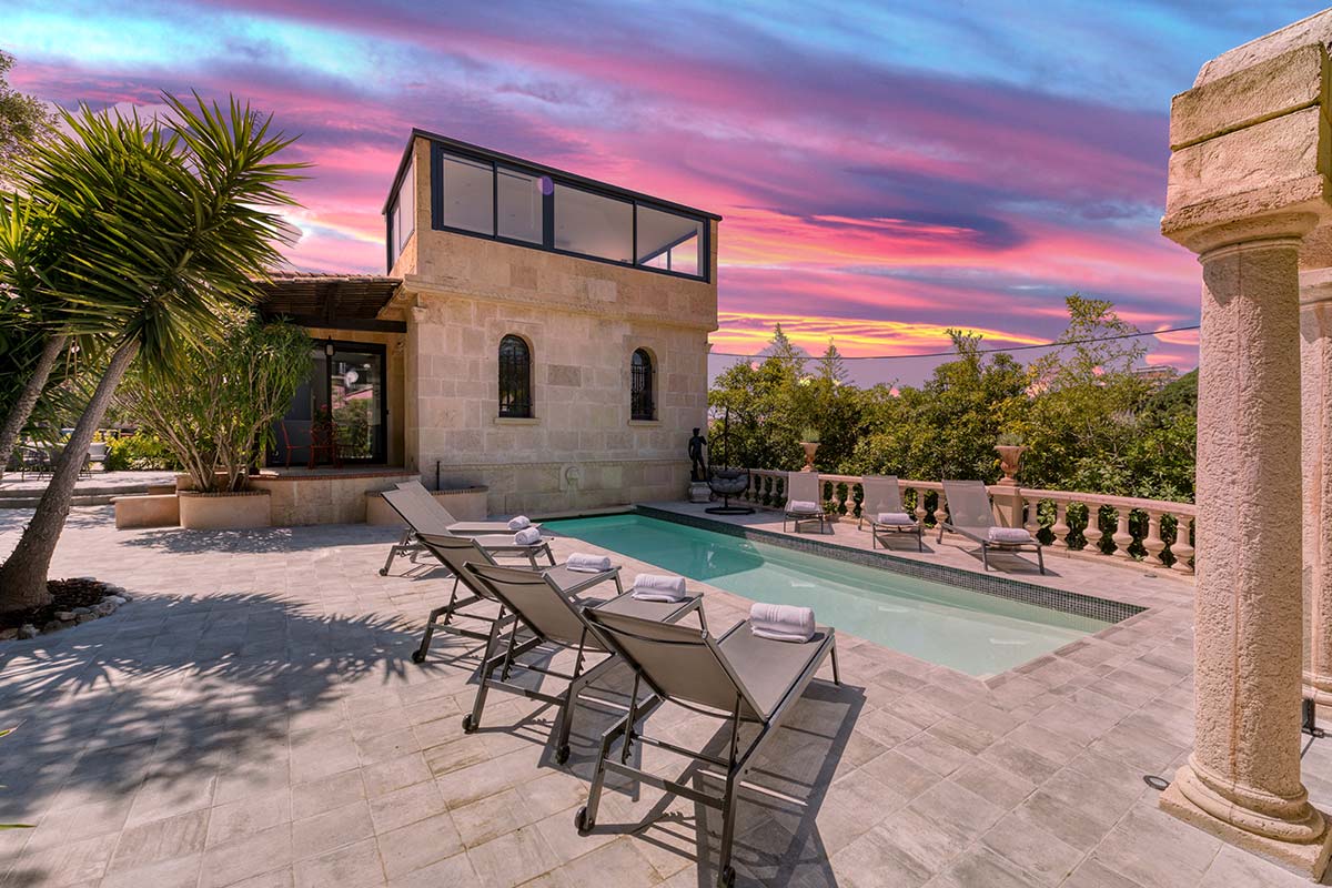 villa-francoise-cannes-for-rent-exterior-pool-terrace Villa Françoise in Cannes – serene French Riviera villa with elegant stone patio, private pool, and loungers under a vivid sunset sky.