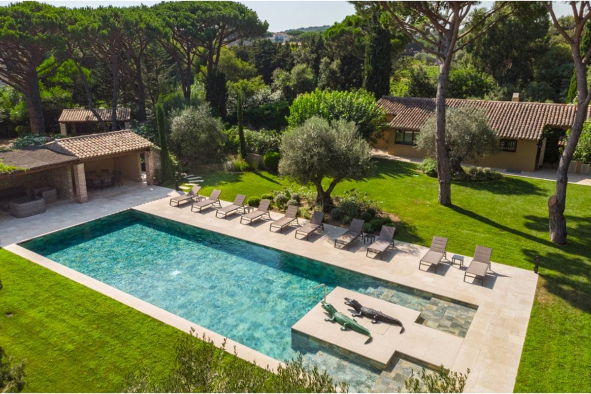 villa-maelis-ramatuelle-for-rent-exterior-pool-garden-view Aerial view of Villa Maelis in Ramatuelle with large outdoor pool, loungers, and a lush garden.